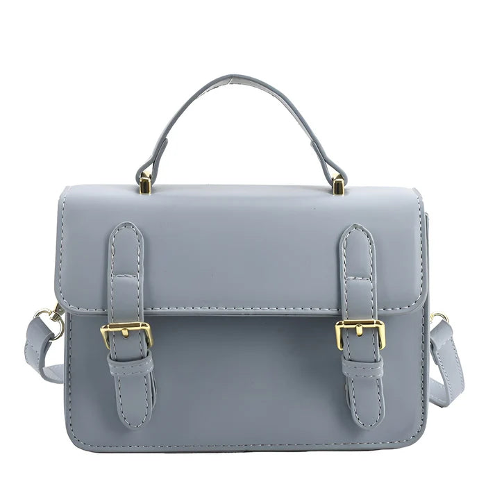Model holding Ishna Bag – minimalist PU leather clutch with flap pocket and hasp closure in compact structured silhouette by Santori The Label