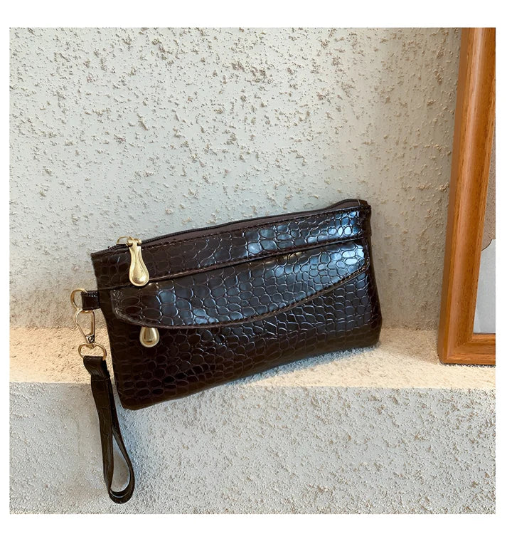 Model holding Bodhi Bag – minimalist PU wallet clutch with zipper closure and sequined sparkle finish by Santori The Label