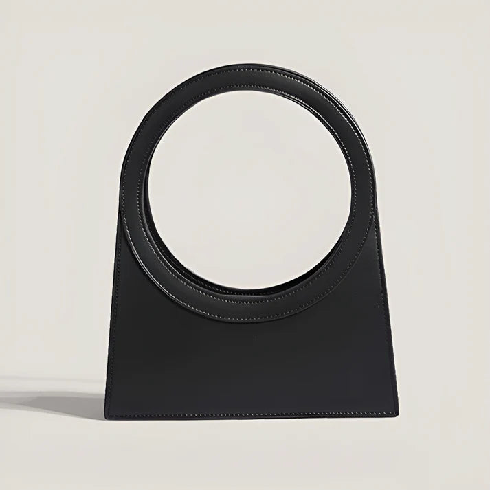 Model holding Miriah Bag – compact PU leather handbag with ring handle, high-end finish, and minimalist motorcycle-inspired design by Santori The Label